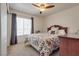 Cozy bedroom with a ceiling fan, window with curtains, and a plush bed with a patterned comforter at 4487 Tomer Ln, Las Vegas, NV 89121