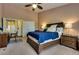 This bedroom features a ceiling fan, carpet flooring, and access to the en suite bathroom and closet at 4487 Tomer Ln, Las Vegas, NV 89121