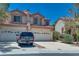 Charming two-story home with a red-tile roof, lush landscaping, and spacious driveway at 4487 Tomer Ln, Las Vegas, NV 89121