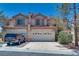 Charming two-story home with a red-tile roof, lush landscaping, and spacious driveway at 4487 Tomer Ln, Las Vegas, NV 89121