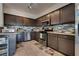 Well-lit kitchen features stainless steel appliances, dark cabinetry, and tiled backsplash at 4487 Tomer Ln, Las Vegas, NV 89121