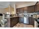 Spacious kitchen with dark wood cabinets, stainless steel appliances, and tiled flooring at 4487 Tomer Ln, Las Vegas, NV 89121