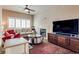 Bright living room features a ceiling fan, fireplace, large TV, and a comfortable sofa at 4487 Tomer Ln, Las Vegas, NV 89121
