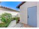 Side view with a gray door and walkway with decorative rock and lush landscaping at 450 Intrepid Ct, Boulder City, NV 89005