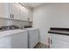 Functional laundry room with white cabinets and a modern washer and dryer at 450 Intrepid Ct, Boulder City, NV 89005