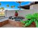 Built-in fire pit on the outdoor bar for a cozy and inviting outdoor atmosphere with tropical plants at 450 Intrepid Ct, Boulder City, NV 89005