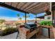 The outdoor kitchen is equipped with a built-in grill and beverage refrigerator for enjoying the outdoors at 450 Intrepid Ct, Boulder City, NV 89005