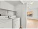 Bright laundry room featuring a washer, a dryer, and white shelving at 4655 Gold Dust Ave # 210, Las Vegas, NV 89120