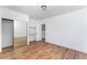 Bedroom showcasing hardwood floors, bright white walls, a mirrored closet, and a view into a bathroom at 517 N 22Nd St, Las Vegas, NV 89101