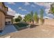 Large backyard featuring a covered patio, gravel, green grass patch, and ample space for outdoor activities at 5229 Giallo Vista Ct, North Las Vegas, NV 89031
