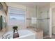 Elegant bathroom featuring a soaking tub, glass-enclosed shower, and neutral tile at 5229 Giallo Vista Ct, North Las Vegas, NV 89031