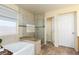 Bathroom featuring a soaking tub, glass-enclosed shower, and neutral colored tile at 5229 Giallo Vista Ct, North Las Vegas, NV 89031