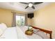 A well-lit bedroom features a ceiling fan, a mounted TV, and decoratively styled bed at 5229 Giallo Vista Ct, North Las Vegas, NV 89031