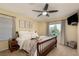 Comfortable bedroom featuring a ceiling fan, a TV, and a beautifully decorated bed at 5229 Giallo Vista Ct, North Las Vegas, NV 89031