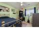 Bedroom with window, ceiling fan, instruments, posters, and light green walls at 5229 Giallo Vista Ct, North Las Vegas, NV 89031