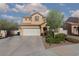 Two-story home featuring a two car garage, desert landscaping, and a well-manicured lawn at 5229 Giallo Vista Ct, North Las Vegas, NV 89031