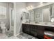 Bright bathroom with dual sinks, dark cabinetry, and a separate toilet and shower area at 5616 Silver Cascade Ave, Las Vegas, NV 89131