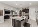 Bright, open concept kitchen with a center island, stainless steel appliances, and views of the living room at 5616 Silver Cascade Ave, Las Vegas, NV 89131