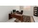 Well-lit home office with a large wooden desk, comfortable chair, and a bookshelf for storage at 5616 Silver Cascade Ave, Las Vegas, NV 89131