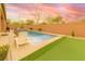 Lush outdoor space featuring a pool, hot tub, and artificial turf area perfect for entertaining and relaxation at 5616 Silver Cascade Ave, Las Vegas, NV 89131