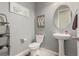 Chic powder room featuring a pedestal sink, decorative mirror, and stylish gray walls at 5616 Silver Cascade Ave, Las Vegas, NV 89131