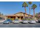 Clubhouse with stucco walls, a brown roof, and a well-maintained parking lot with mature palm trees at 7200 Pirates Cove Rd # 2084, Las Vegas, NV 89145