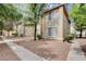 Beige two story home with trees, bushes, and gravel landscape in front at 7200 Pirates Cove Rd # 2084, Las Vegas, NV 89145