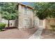 Tan two-story home with a sidewalk, bushes, trees, and windows at 7200 Pirates Cove Rd # 2084, Las Vegas, NV 89145