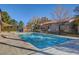 Community pool with clear water and a tiled pool deck surrounded by mature trees at 7200 Pirates Cove Rd # 2084, Las Vegas, NV 89145