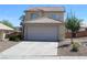 Beige two story home featuring a tile roof, two car garage and low maintenance landscaping at 730 Goshawk St, Henderson, NV 89015
