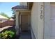 Beige front entrance and door with bushes and landscaping next to the covered entryway at 730 Goshawk St, Henderson, NV 89015