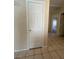 Neutral hallway with tile flooring and a white door with a view into a carpeted bedroom at 732 Goshawk St, Henderson, NV 89015