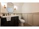 Elegant powder room with dark vanity, white countertops, and classic wainscoting, offering a stylish retreat at 8140 Bay Harbor Dr, Las Vegas, NV 89128
