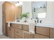 Bathroom featuring a double vanity with wood cabinets, white countertops, black fixtures, and stylish decor at 8140 Bay Harbor Dr, Las Vegas, NV 89128