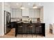 Modern kitchen with black marble island, stainless steel refrigerator, and pendant lighting at 8140 Bay Harbor Dr, Las Vegas, NV 89128