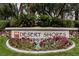 Desert Shores community entrance sign beautifully landscaped with colorful flowers and lush greenery at 8140 Bay Harbor Dr, Las Vegas, NV 89128