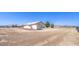 Wide view of the home's backyard, revealing a large, empty space and the home's exterior at 861 S Ford Loop, Pahrump, NV 89048