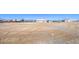 Large, flat parcel of land with the home in the distance; a buyer could create anything here at 861 S Ford Loop, Pahrump, NV 89048