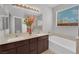 Bathroom featuring double sinks, a soaking tub, and a glass-enclosed shower at 9467 Samuel Clemens Ct, Las Vegas, NV 89147
