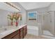 Bathroom featuring double sinks, a soaking tub, and a glass-enclosed shower at 9467 Samuel Clemens Ct, Las Vegas, NV 89147