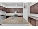 An island sink and granite countertop are featured in this kitchen with dark cabinets at 9467 Samuel Clemens Ct, Las Vegas, NV 89147