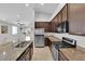 Open concept kitchen with stainless appliances, granite countertops and dark cabinets at 9467 Samuel Clemens Ct, Las Vegas, NV 89147