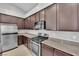 Kitchen featuring granite countertops, stainless steel appliances, and dark wood cabinets at 9467 Samuel Clemens Ct, Las Vegas, NV 89147