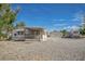 Exterior view of a single-story home with a gravel yard and a detached two-car garage at 960 Third St, Pahrump, NV 89048