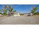 Exterior view of a single-story home with a gravel yard and a detached two-car garage at 960 Third St, Pahrump, NV 89048