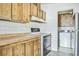 View of kitchen area with white appliances, tile backsplash, and wood cabinets at 960 Third St, Pahrump, NV 89048