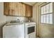 The laundry room features a washer and dryer, cabinets, and a window for ventilation at 960 Third St, Pahrump, NV 89048