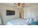 Bright bedroom features a ceiling fan, mounted TV, and a closet for organized storage at 10031 Fletcher Peak Ave, Las Vegas, NV 89178