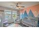 Adorable Bedroom with mountain mural, plush chair, and crib with natural light from two windows at 10031 Fletcher Peak Ave, Las Vegas, NV 89178