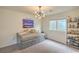 Cozy bedroom featuring modern light fixture and window at 10031 Fletcher Peak Ave, Las Vegas, NV 89178